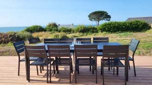 a dining table and chairs with the ocean in the background at T'Albert Einstein in Pleubian