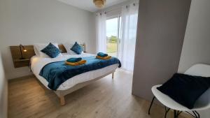 a bedroom with a bed with blue pillows and a window at T'Albert Einstein in Pleubian