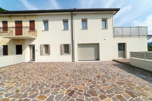 Una gran casa blanca con un camino de entrada de piedra. en EnJoy Home - Appartamento Terra, Il Canterale, en Galzignano Terme