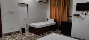 a small room with a bed and a mirror at Kaziranga Homestay in Guwahati