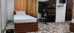 a bedroom with a bed and a table and a television at Kaziranga Homestay in Guwahati