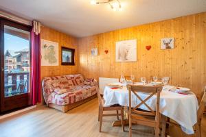 a dining room with a table and a couch at Joli Appt 2 Centre Village Valloire in Valloire