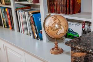 a globe sitting on a counter next to a book shelf at Manoir d Armagnac in Courrensan