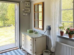 a room with a dresser next to a window at 4 person holiday home in Furuby in Furuby +33 photos