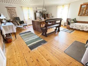 a living room with a wooden floor and a piano at 4 person holiday home in Furuby in Furuby
