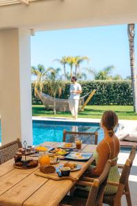 a woman sitting at a table with food on it at TAF Beach Villas with TESLA in Tigaki +30 photos