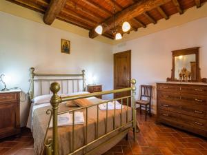 a bedroom with a bed and a dresser at Farmhouse in Tuscany with Panoramic Pool in Castiglion Fiorentino