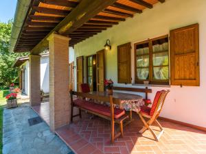 an outdoor patio with a wooden table and chairs at Farmhouse in Tuscany with Panoramic Pool in Castiglion Fiorentino