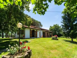 a house with a yard with flowers in front of it at Farmhouse in Tuscany with Panoramic Pool in Castiglion Fiorentino