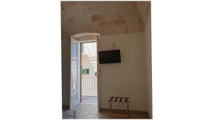 a room with a door and a chair and a television at Masi suite in Monopoli