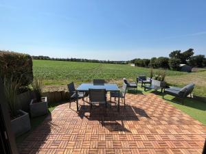 Noyal-PontivyLa villa Pontivyenne的带桌椅和田野的露台