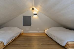 a bedroom with two beds and a light on the wall at Chalet Cosy neuf sur terrain privé clôturé 600m2 in Faverges