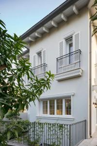 a white house with balconies and a fence at Carmelo Congress Villa in Herzliya Pituah