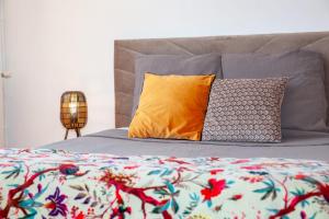 a bed with a colorful blanket and pillows on it at Manoir d Armagnac in Courrensan +15 photos
