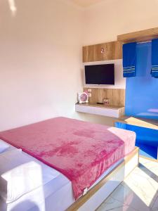 Un dormitorio con una cama y un televisor en una pared. en Hotel Asia Express near Farmhouse Lembang, en Lembang 32 fotos más