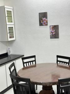 a table in a kitchen with three pictures on the wall at Sena Sweet Home in Pokok Sena +11 photos