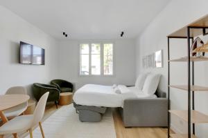 a bedroom with a bed and a table and chairs at Appartement moderne et tout équipé in La Plaine-Saint-Denis