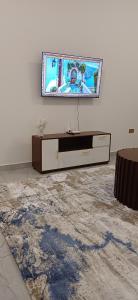 Una sala de estar con un televisor en una pared blanca. en Havy Homes 2 Bedroom Apartment Malindi, en Malindi