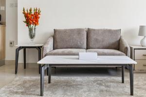 un soggiorno con un divano e un tavolo di Unlock Metropolis Business Bay a Dubai