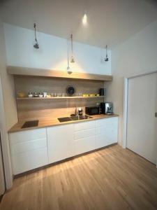a kitchen with white cabinets and a sink at Ubytování v srdci Písku in Písek