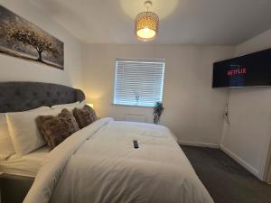 a bedroom with a large white bed and a window at The Charm Luxury House - 8mins to NEC, Birmingham Airport in Marston Green