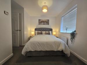 a bedroom with a bed and a window at The Charm Luxury House - 8mins to NEC, Birmingham Airport in Marston Green