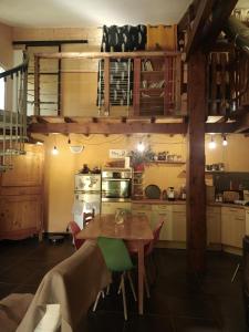 a kitchen with a wooden table and a kitchen with a stove at Les amandiers in Gigors