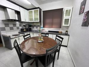 a kitchen with a wooden table and chairs in it at Sena Sweet Home in Pokok Sena