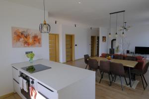 a kitchen and living room with a table and chairs at Červene maky - red poppies in Malý Slavkov