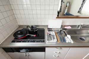 un bancone da cucina con fornelli e lavello di Hongo Street House - Vacation STAY 8609 a Sapporo Altre 71 foto