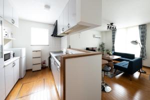 una cucina e un soggiorno con armadi bianchi e tavolo di Hongo Street House - Vacation STAY 8609 a Sapporo