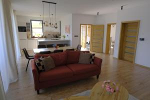 a living room with a red couch and a table at Červene maky - red poppies in Malý Slavkov +33 photos