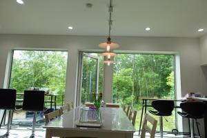 a dining room with a table and chairs and large windows at CLOUD9 - Vacation STAY 45821v in Rusutsu +4 photos