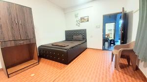 a bedroom with a black leather bed in a room at Baga Haven Guesthouse in Baga +16 photos