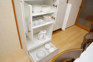 a cupboard with plates and dishes on it at YUFUIN KYOAN - Vacation STAY 87589 in Yufuin +43 photos