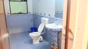 a bathroom with a toilet and a sink at Baga Haven Guesthouse in Baga