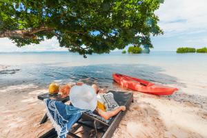 zwei Kinder auf einem Stuhl am Strand in der Unterkunft Amorita Resort Palawan in Puerto Princesa