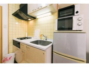 a small kitchen with a sink and a microwave at VIEW HAKATA - Vacation STAY 87980 in Fukuoka +9 photos