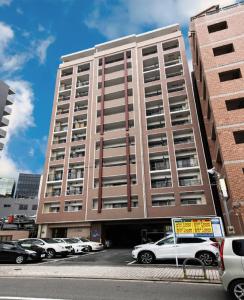 a tall building with cars parked in a parking lot at VIEW HAKATA - Vacation STAY 87980 in Fukuoka