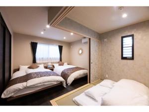 a bedroom with two beds and a window at BEPPU NO YU SARA - Vacation STAY 87960 in Beppu