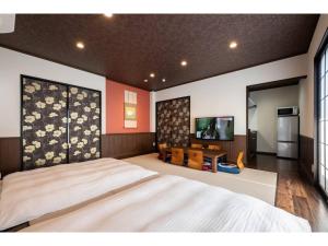 une chambre avec un grand lit et une télévision à écran plat dans l'établissement KOTONONE MAI - Vacation STAY 87621, à Yufu