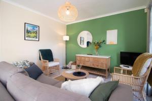 un soggiorno con un divano e una TV di 19 Pachena at Robberg Beach a Plettenberg Bay