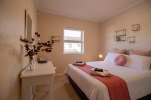 una camera da letto con un letto, un tavolo e una finestra di 19 Pachena at Robberg Beach a Plettenberg Bay Altre 16 foto