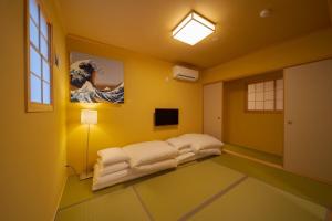 a yellow room with a bed and a painting on the wall at NAGOMIYA - Vacation STAY 87640 in Yufuin