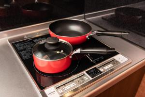 two pots and pans sitting on top of a stove at NAGOMIYA - Vacation STAY 87640 in Yufuin