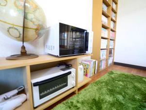 a room with a microwave and a television on a shelf at Kochi - House - Vacation STAY 88439 in Kochi