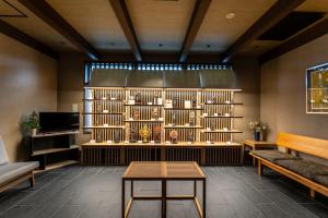 a room with a book shelf and a table at Temple Town Hotel WAQOO Horyuji in Ikaruga