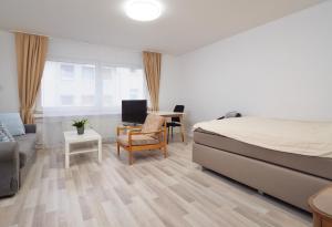 ケルンにあるBeautiful apartments in the middle of Cologneのベッドとソファと机のある寝室