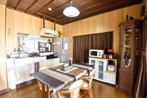 a kitchen with a table and chairs and a refrigerator at Nago - House - Vacation STAY 88505 in Nago