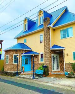 ein gelbes und blaues Haus mit blauem Dach in der Unterkunft South Shore - Vacation STAY 89347 in Kannoura